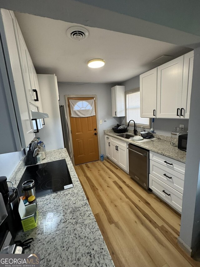 2461 Mcalpin Ter, East Point, GA 30344 - kitchen featuring black appliances, white cabinetry, light wood-style floors, and light stone counters