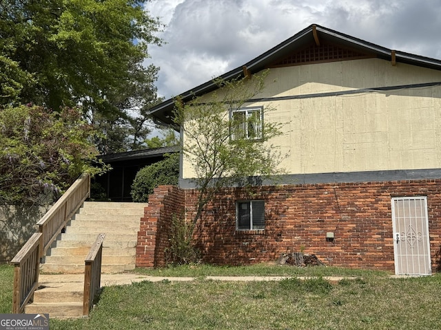 2461 Mcalpin Ter, East Point, GA 30344 - view of property exterior with stairs, a yard, and brick siding