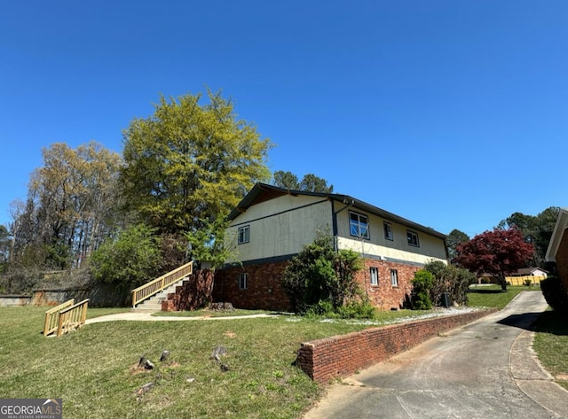 2461 Mcalpin Ter, East Point, GA 30344 - view of property exterior featuring a lawn, stairs, and brick siding