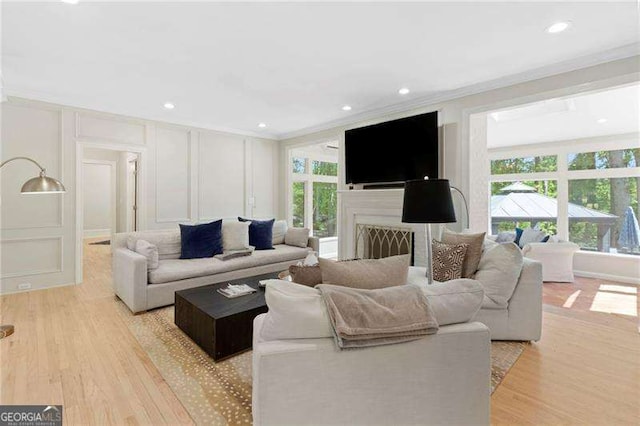 5790 Heards Forest Dr, Atlanta, GA 30328 - living room featuring crown molding, light wood finished floors, plenty of natural light, and a decorative wall