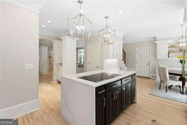 5790 Heards Forest Dr, Atlanta, GA 30328 - kitchen with ornamental molding, light wood finished floors, black electric stovetop, a notable chandelier, and dark cabinetry