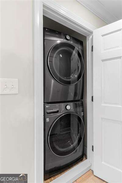 5790 Heards Forest Dr, Atlanta, GA 30328 - laundry area featuring laundry area, light wood finished floors, and stacked washer / drying machine