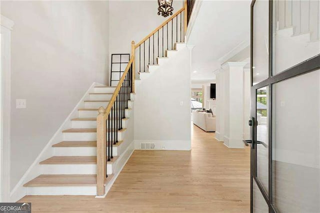 5790 Heards Forest Dr, Atlanta, GA 30328 - staircase featuring baseboards, a high ceiling, wood finished floors, and visible vents