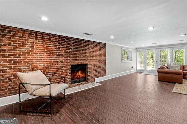 5790 Heards Forest Dr, Atlanta, GA 30328 - living area with a brick fireplace, baseboards, wood finished floors, visible vents, and ornamental molding