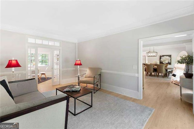 5790 Heards Forest Dr, Atlanta, GA 30328 - living area featuring crown molding, baseboards, french doors, light wood-style flooring, and a notable chandelier