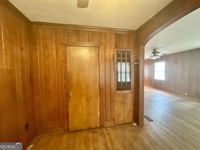 623 Mcdonald St, Waycross, GA 31503 - empty room with ceiling fan, wood finished floors, arched walkways, crown molding, and wood walls