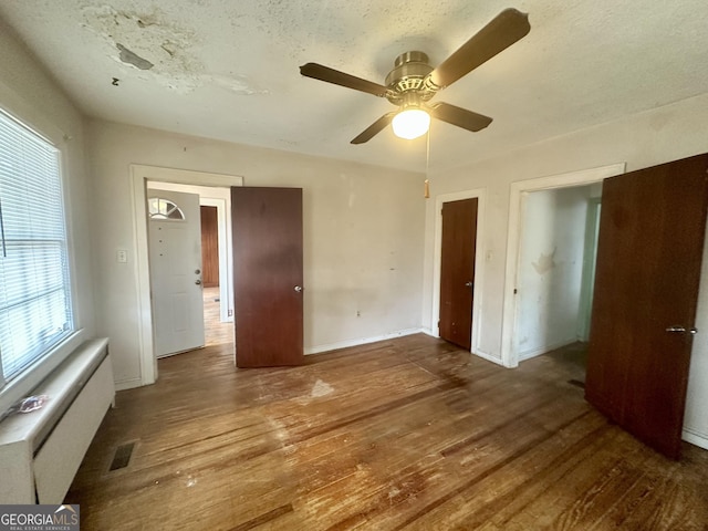 623 Mcdonald St, Waycross, GA 31503 - unfurnished bedroom with wood finished floors, ceiling fan, and radiator heating unit