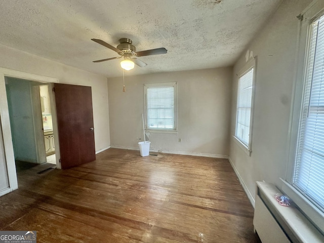 623 Mcdonald St, Waycross, GA 31503 - unfurnished bedroom featuring a textured ceiling, wood finished floors, ceiling fan, and radiator
