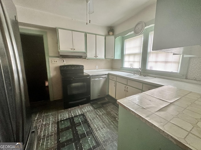 623 Mcdonald St, Waycross, GA 31503 - kitchen featuring black electric range, stainless steel dishwasher, under cabinet range hood, white cabinets, and tile countertops