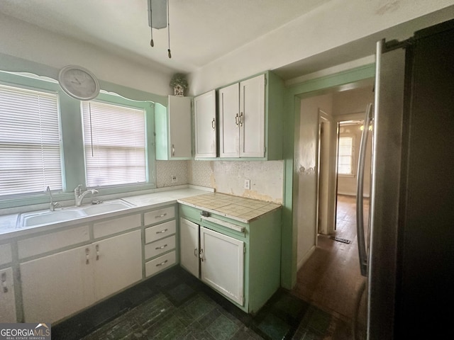 623 Mcdonald St, Waycross, GA 31503 - kitchen featuring freestanding refrigerator, white cabinets, and backsplash
