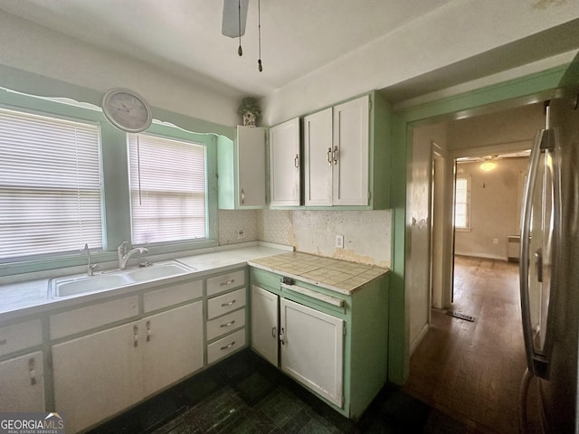 623 Mcdonald St, Waycross, GA 31503 - kitchen featuring freestanding refrigerator, white cabinets, ceiling fan, dark wood-type flooring, and tile counters