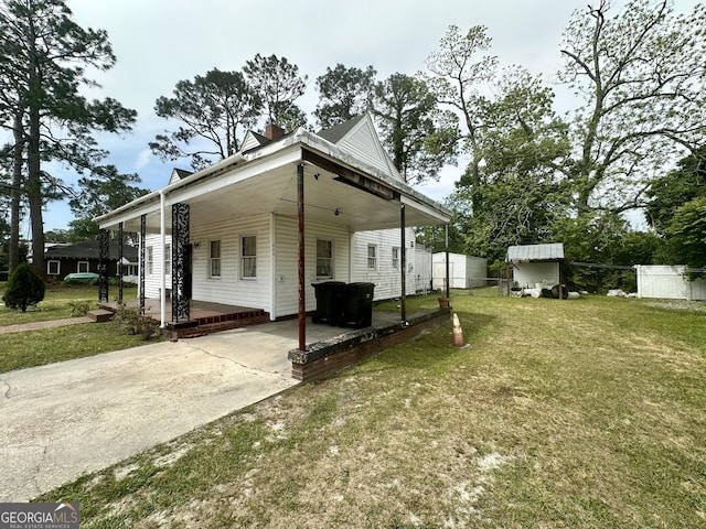 623 Mcdonald St, Waycross, GA 31503 - rear view of house with a carport, driveway, a storage shed, a patio area, and a chimney