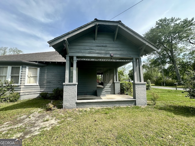 2409 Dorothy St, Waycross, GA 31501 - back of property featuring a lawn, a porch, and a shingled roof
