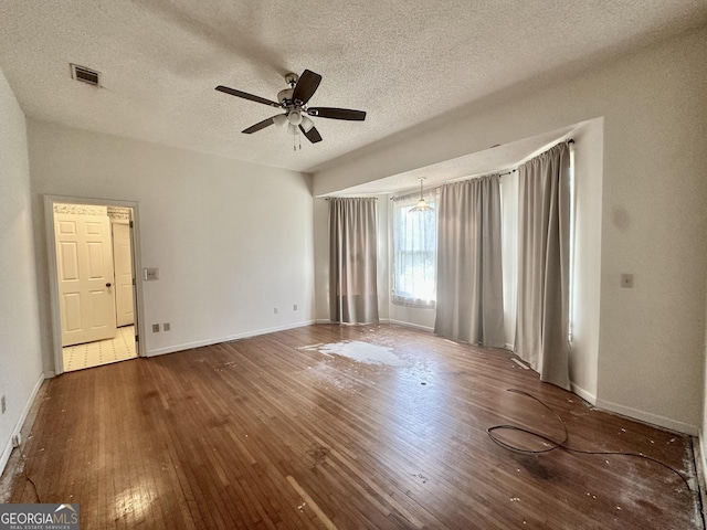 2409 Dorothy St, Waycross, GA 31501 - empty room featuring a textured ceiling, wood-type flooring, a ceiling fan, and baseboards