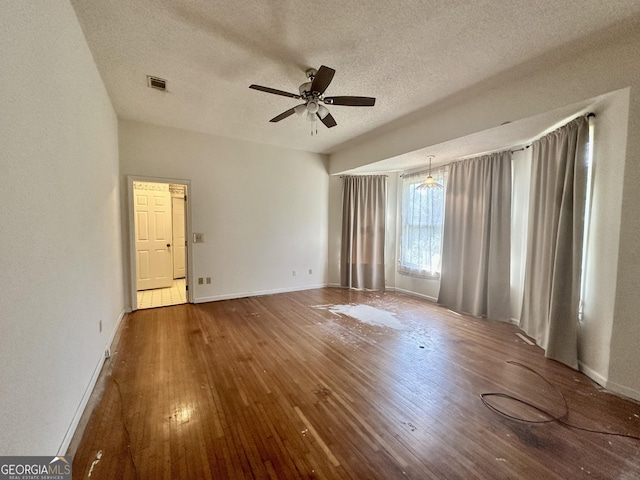 2409 Dorothy St, Waycross, GA 31501 - empty room with a ceiling fan, wood-type flooring, a textured ceiling, and baseboards