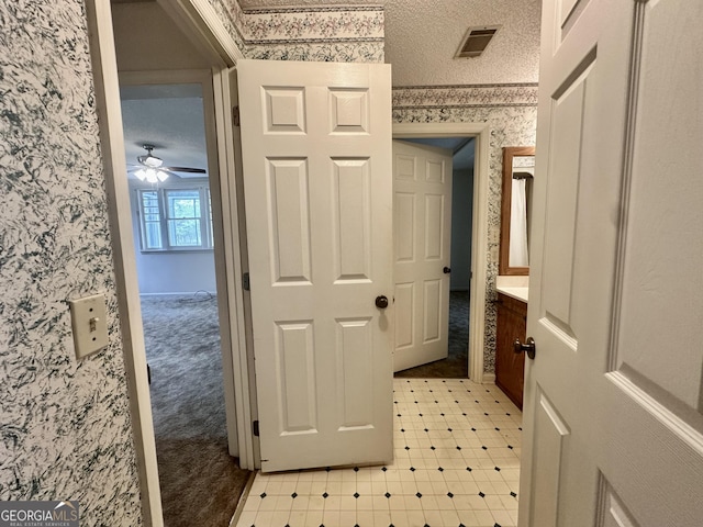 2409 Dorothy St, Waycross, GA 31501 - corridor featuring wallpapered walls, a textured ceiling, light carpet, and light flooring