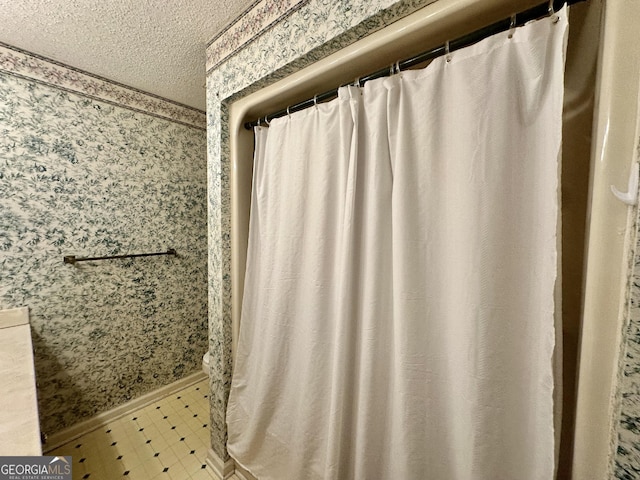 2409 Dorothy St, Waycross, GA 31501 - full bathroom with wallpapered walls, a textured ceiling, tile patterned floors, and baseboards