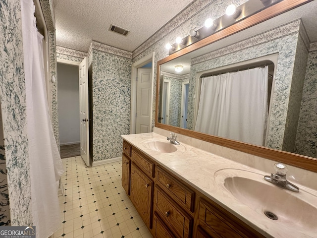2409 Dorothy St, Waycross, GA 31501 - bathroom with wallpapered walls, a textured ceiling, and double vanity