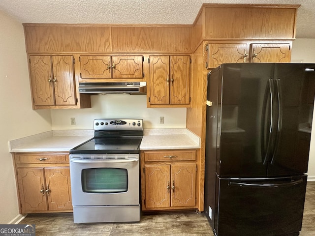 2409 Dorothy St, Waycross, GA 31501 - kitchen featuring freestanding refrigerator, electric stove, under cabinet range hood, a textured ceiling, and light countertops