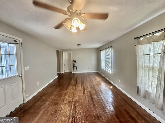 2409 Dorothy St, Waycross, GA 31501 - unfurnished living room with wood-type flooring, a ceiling fan, baseboards, and a textured ceiling