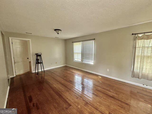 2409 Dorothy St, Waycross, GA 31501 - empty room featuring wood finished floors, a textured ceiling, and baseboards