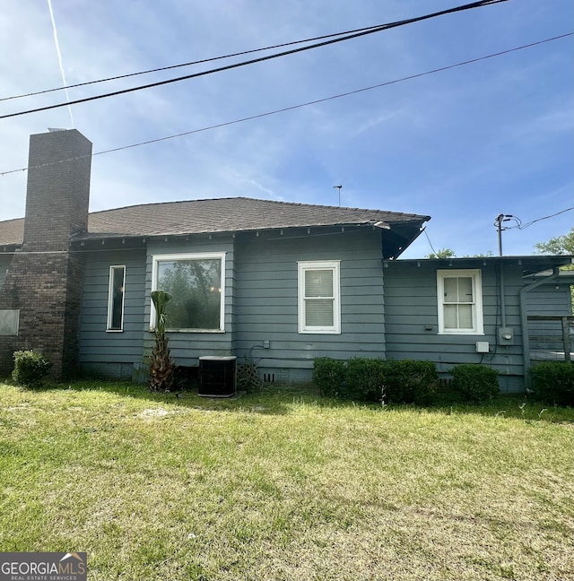 2409 Dorothy St, Waycross, GA 31501 - back of property with cooling unit, a lawn, and a shingled roof