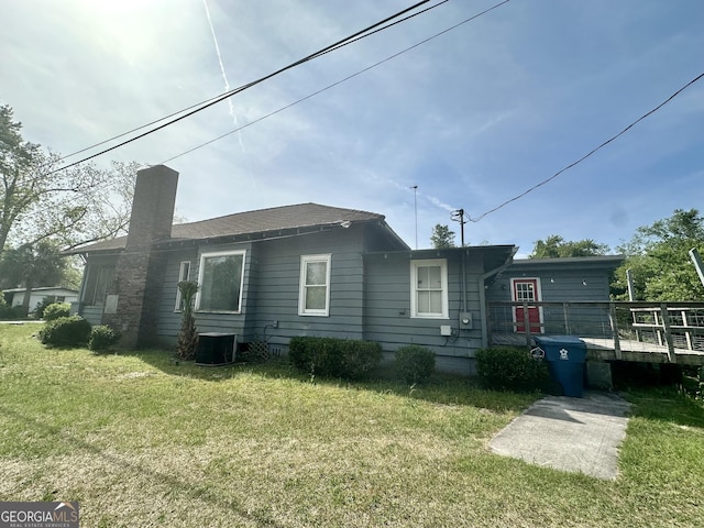 2409 Dorothy St, Waycross, GA 31501 - back of house featuring a chimney, a deck, a lawn, and cooling unit