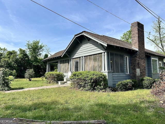 2409 Dorothy St, Waycross, GA 31501 - view of property exterior with a chimney, a yard, and board and batten siding
