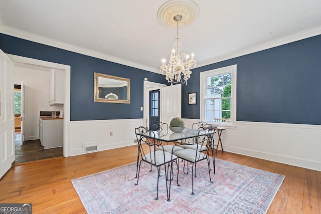 1419 Briarcliff Rd, Macon, GA 31201 - dining room with a wainscoted wall, visible vents, an inviting chandelier, crown molding, and wood-type flooring