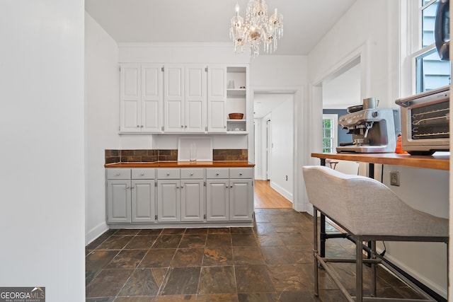 1419 Briarcliff Rd, Macon, GA 31201 - kitchen with open shelves, a toaster, white cabinets, baseboards, and stone finish floor