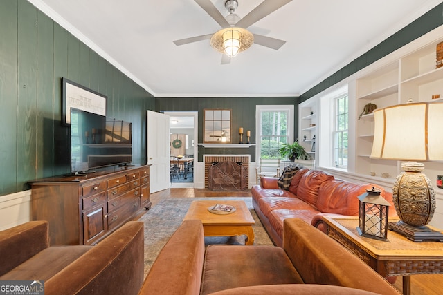 1419 Briarcliff Rd, Macon, GA 31201 - living area featuring built in shelves, a ceiling fan, wood finished floors, wooden walls, and ornamental molding