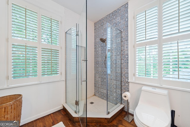 1419 Briarcliff Rd, Macon, GA 31201 - bathroom with baseboards, toilet, wood finished floors, and a stall shower
