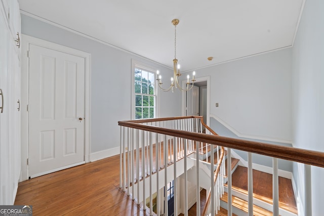 1419 Briarcliff Rd, Macon, GA 31201 - hall featuring an inviting chandelier, an upstairs landing, crown molding, baseboards, and light wood-style flooring