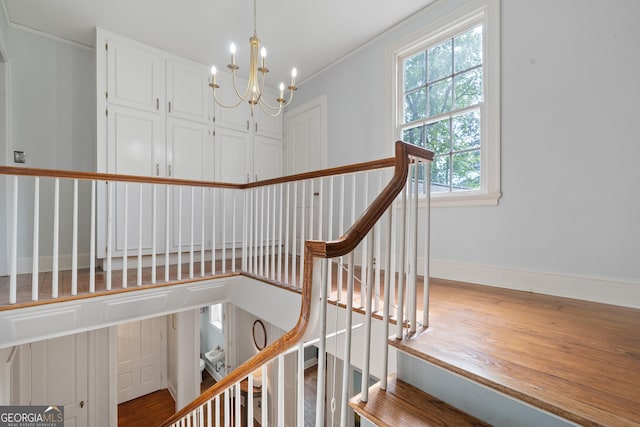1419 Briarcliff Rd, Macon, GA 31201 - stairs with wood finished floors, crown molding, baseboards, and an inviting chandelier