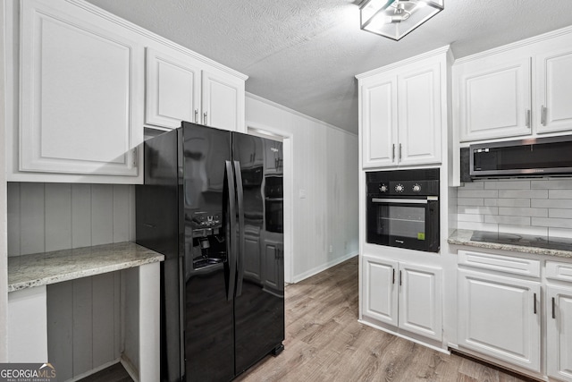 851 Rockbridge Rd SW, Lilburn, GA 30047 - kitchen featuring black appliances, light wood-style flooring, backsplash, white cabinetry, and a textured ceiling
