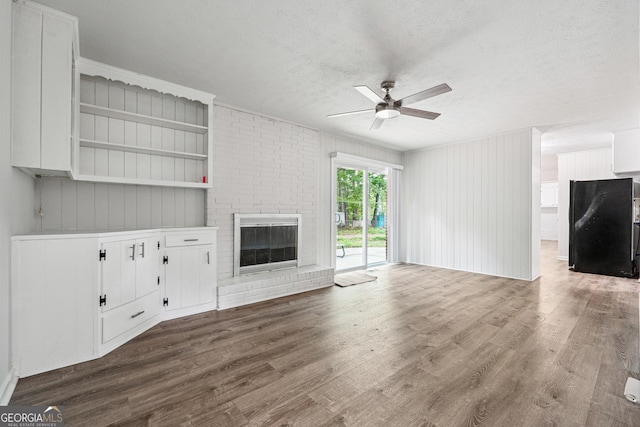 851 Rockbridge Rd SW, Lilburn, GA 30047 - unfurnished living room featuring dark wood-style floors, ceiling fan, a textured ceiling, and a fireplace