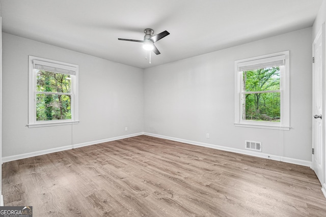 851 Rockbridge Rd SW, Lilburn, GA 30047 - spare room with visible vents, wood finished floors, a wealth of natural light, and ceiling fan
