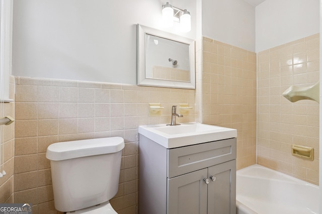 851 Rockbridge Rd SW, Lilburn, GA 30047 - bathroom featuring tub / shower combination, toilet, tile walls, vanity, and wainscoting