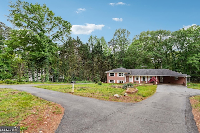 851 Rockbridge Rd SW, Lilburn, GA 30047 - tri-level home featuring a front yard, a carport, aphalt driveway, and a view of trees