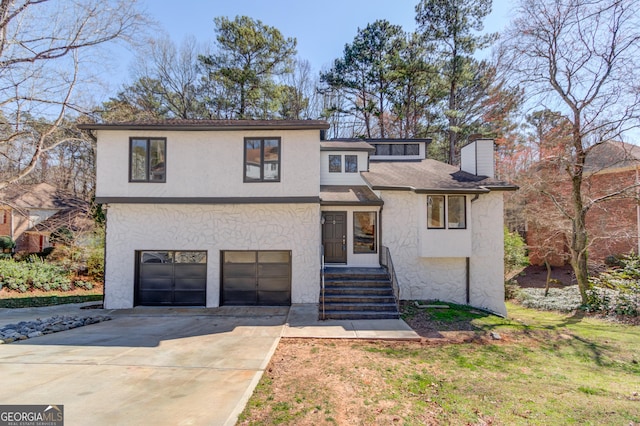view of front of property with stucco siding, concrete driveway, a chimney, and a garage