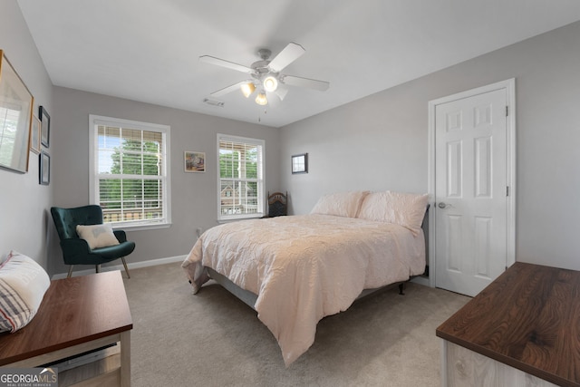 bedroom featuring baseboards, light colored carpet, and ceiling fan