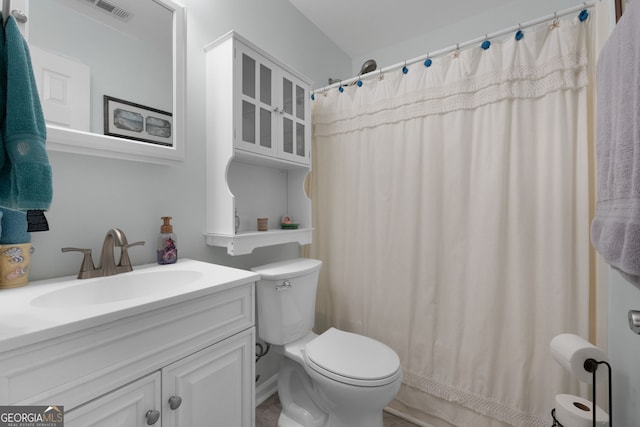 full bathroom featuring toilet, vanity, and visible vents