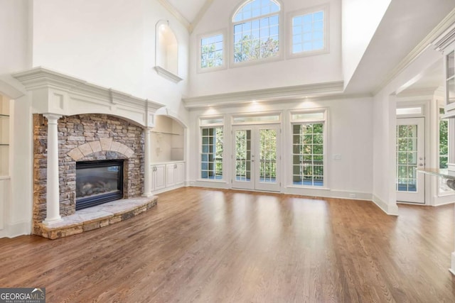 2480 Flint Creek Dr, Cumming, GA 30041 - unfurnished living room with a stone fireplace, a high ceiling, built in shelves, and a healthy amount of sunlight