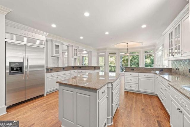 2480 Flint Creek Dr, Cumming, GA 30041 - kitchen featuring a peninsula, stainless steel built in fridge, crown molding, and white cabinetry