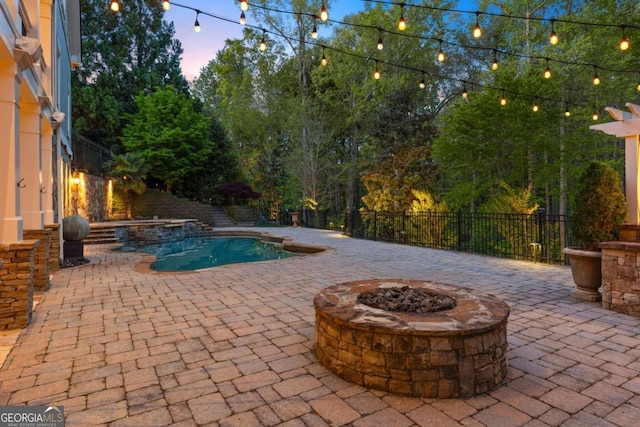 2480 Flint Creek Dr, Cumming, GA 30041 - pool at dusk featuring a fire pit, a pool with connected hot tub, a patio, and fence