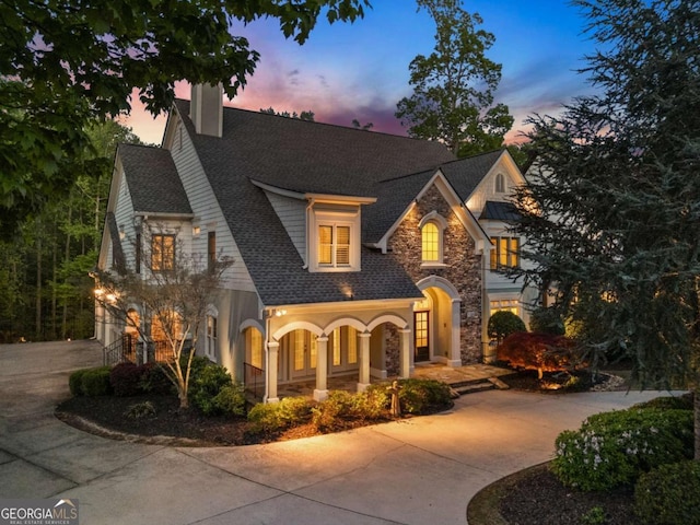 2480 Flint Creek Dr, Cumming, GA 30041 - view of front of house featuring a chimney, curved driveway, stone siding, roof with shingles, and a garage