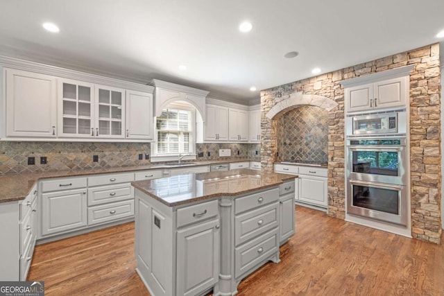 2480 Flint Creek Dr, Cumming, GA 30041 - kitchen featuring appliances with stainless steel finishes, a sink, white cabinetry, and a kitchen island