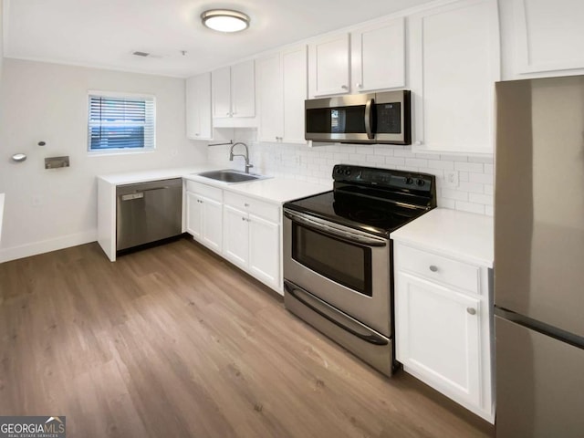 165 N River Dr Unit B, Atlanta, GA 30350 - kitchen featuring appliances with stainless steel finishes, tasteful backsplash, wood finished floors, and white cabinets
