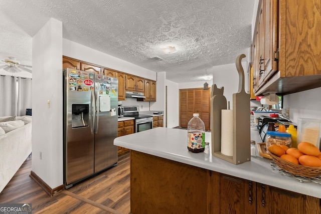 4701 Cleveland Hwy, Gainesville, GA 30506 - kitchen with stainless steel appliances, a textured ceiling, brown cabinets, dark wood-style floors, and under cabinet range hood
