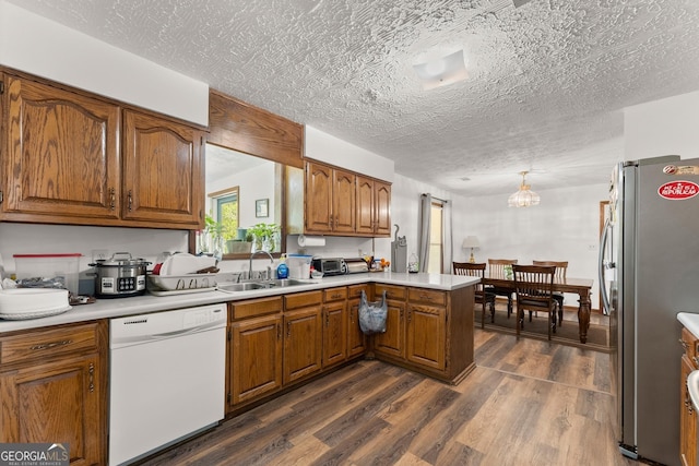 4701 Cleveland Hwy, Gainesville, GA 30506 - kitchen with dishwasher, freestanding refrigerator, a sink, brown cabinetry, and a textured ceiling
